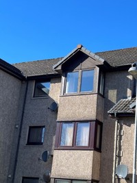 Front of the block with windows and sloped roof