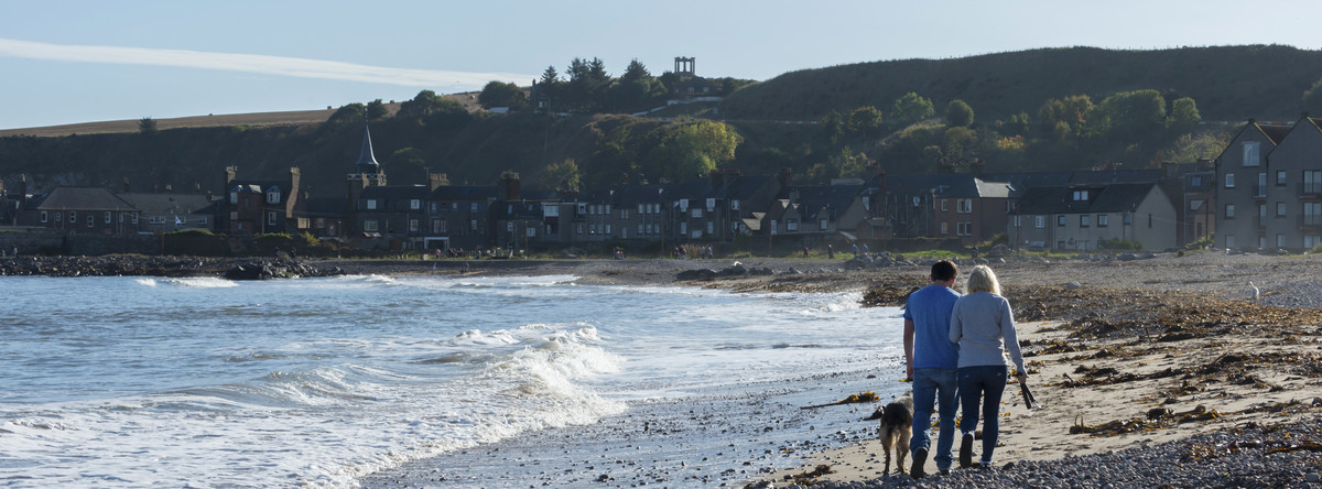 Couple walking on Stonehaven beach