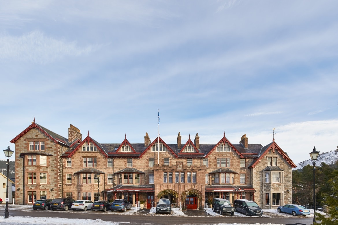 The Fife Arms project showing a long building with cars in front and snowy road