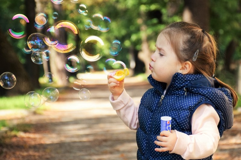 Little girl making soap bubbles