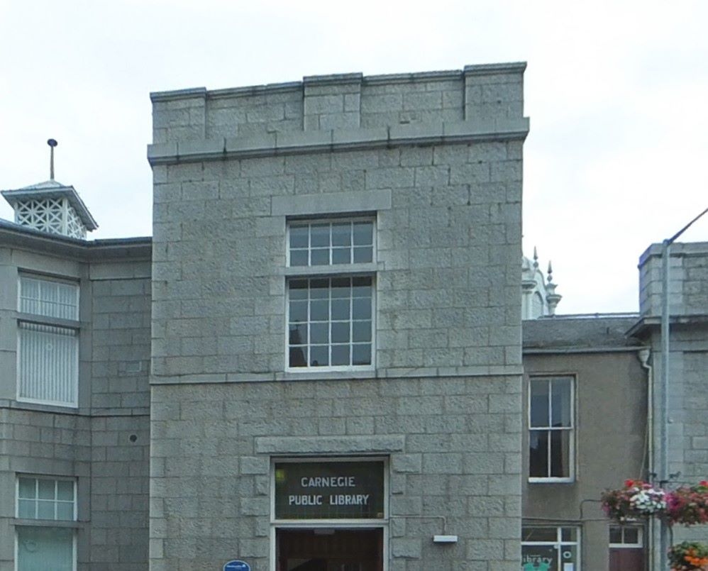 The frontage of Inverurie Library. The library's formal name, Carnegie Public Library, is printed in white on a glass panel above the door. 
