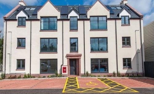 Front of 12 David House, Stonehaven showing a block of flats with parking spaces in front