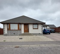 Front of the bungalow bay window and front door in the middle,  tarmac driveway and  gravel at the front