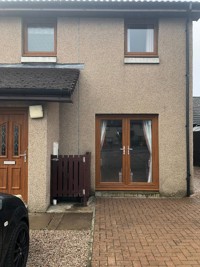 End terraced house with driveway, front door no the left and patio door on the right