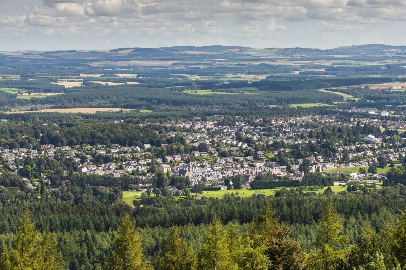 An aerial picture of Banchory showing houses, buildings and surrounding forestry and hills