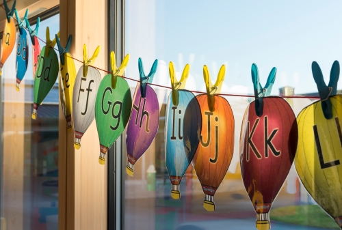 Hot air balloon cut outs with the alphabet hanging on a window