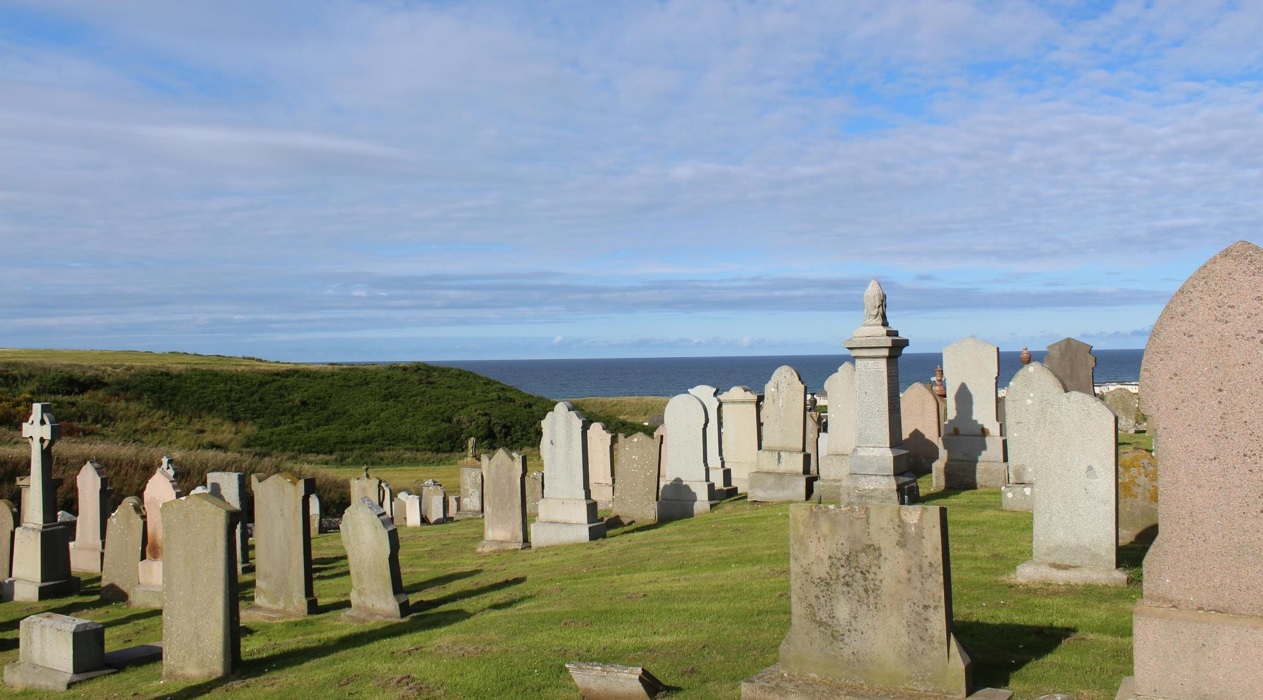 A picture of headstones at St Brandon's Church at Inverboyndie looking out to the North Sea