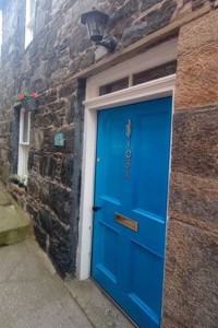 Property wall made of stone with blue front door